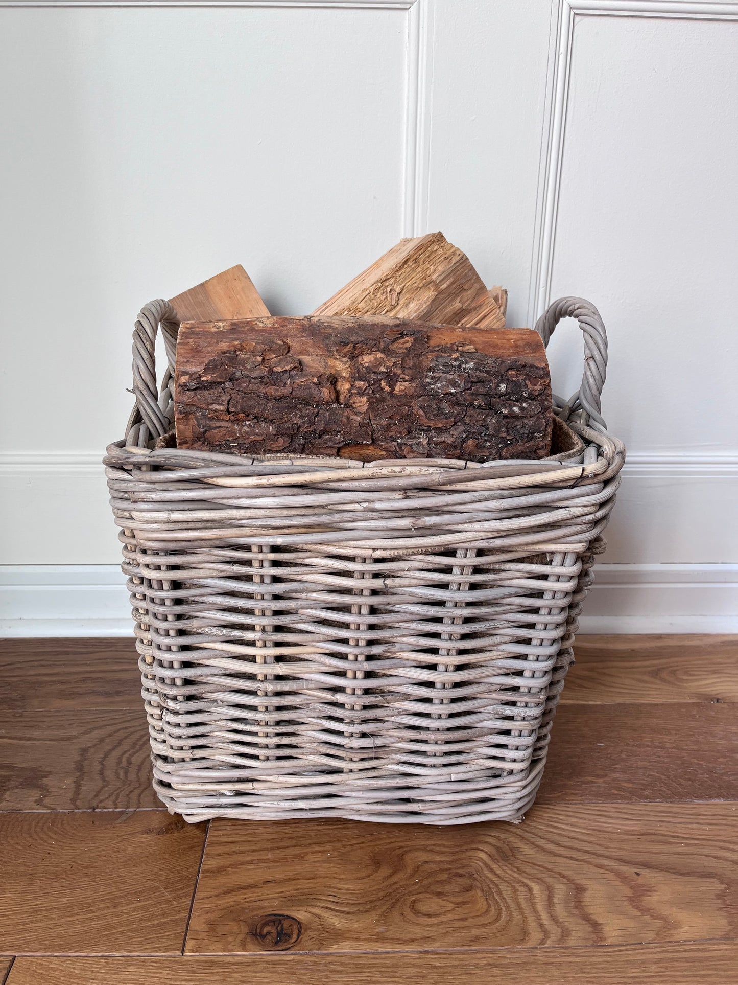 side view of square rattan basket with basket displaying logs