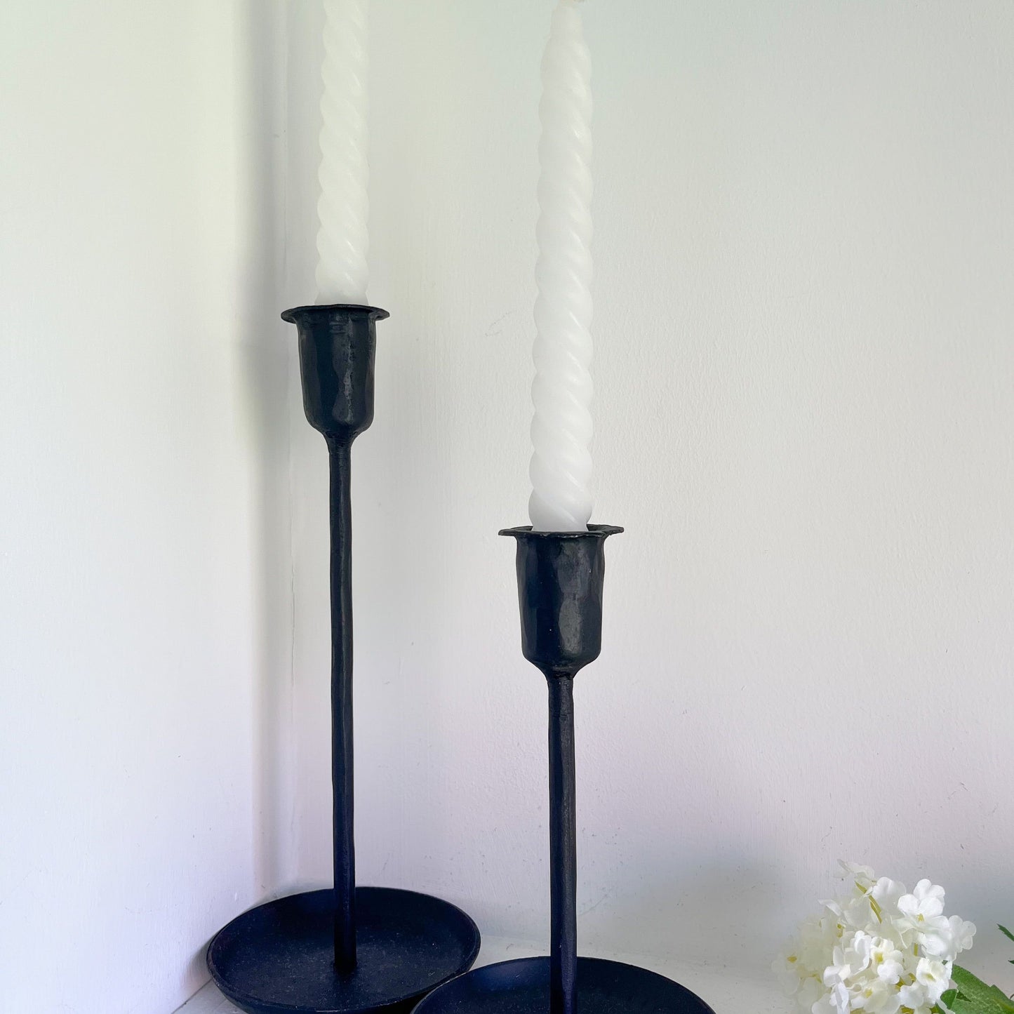 large and small black iron dinner candle holders styled with white dinner candles