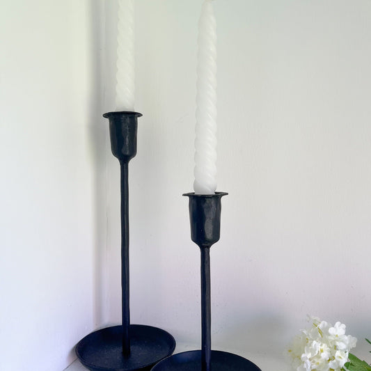 large and small black iron dinner candle holders styled with white dinner candles