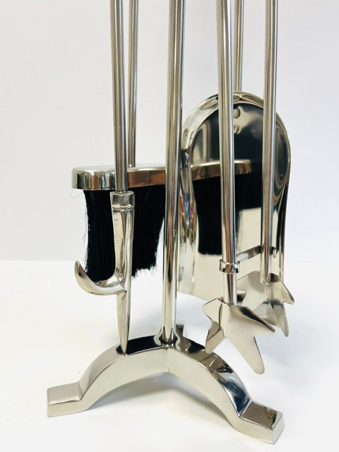 Chrome fireplace tool set with black brush on a white background
