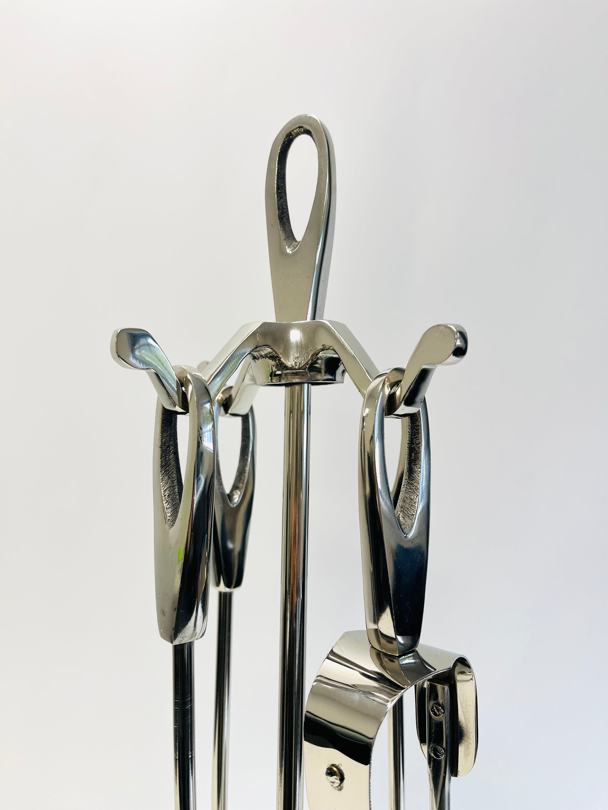 Set of metal fire tools including a poker, shovel, and tongs on a white background