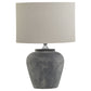 close up view of rustic grey stone lamp and linen shade