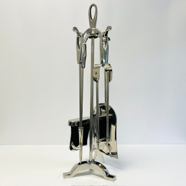 Set of silver fireplace tools on a white background