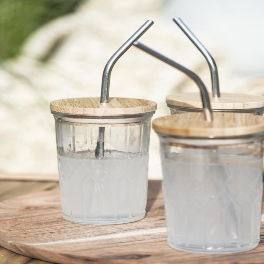 three outdoor drinking glasses with bamboo lid and stainless steel straw. Diamond detail on glass base.